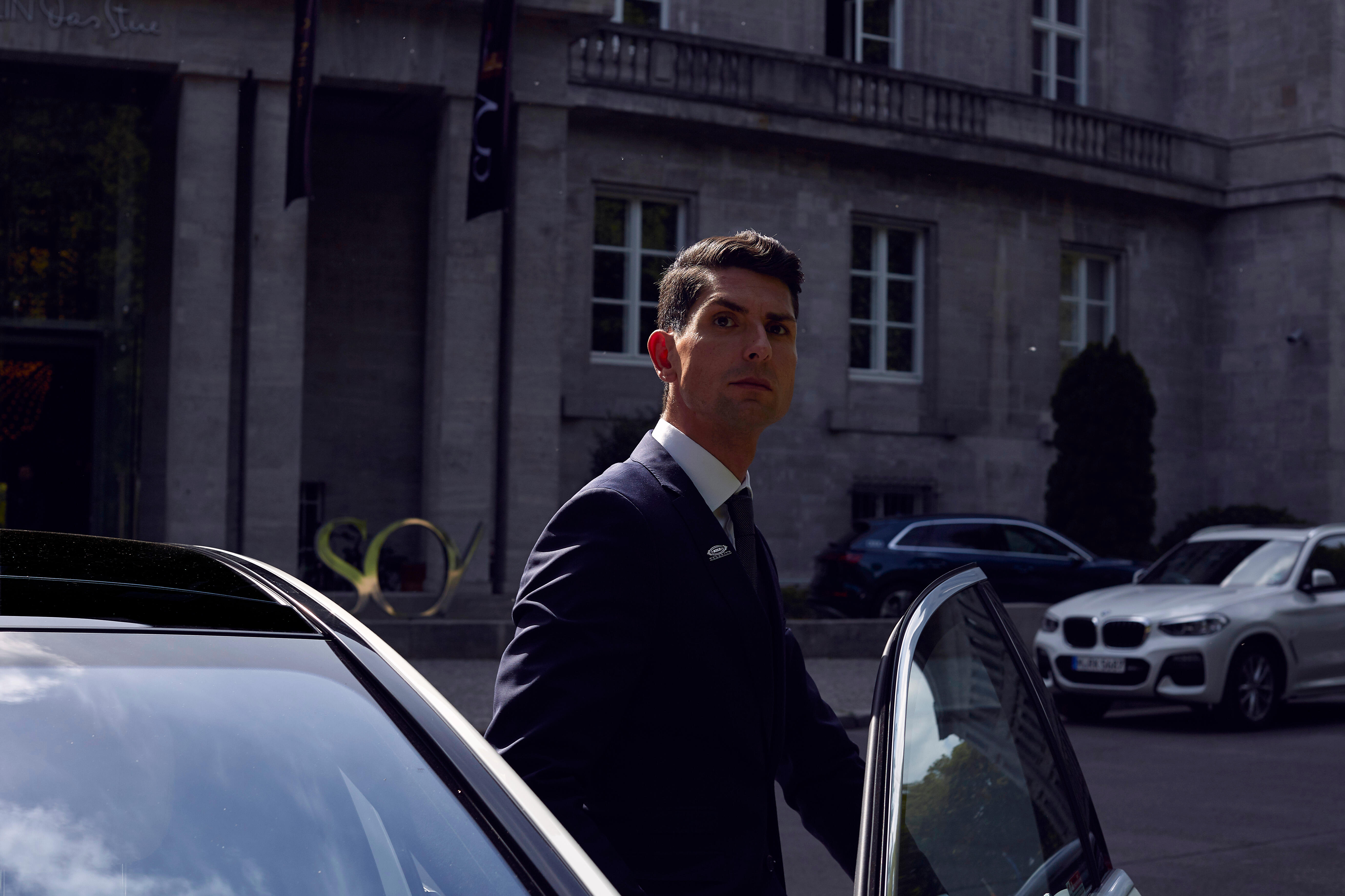 Fahrer öffnet Tür eines Oberklasse-Wagens